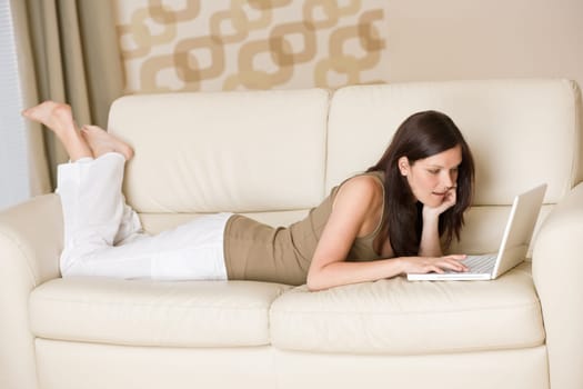 Young woman with laptop on sofa home