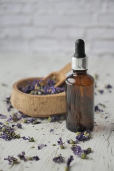 Essential lavender oil and flowers on table with copy space .