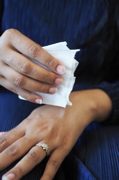women disinfecting her hands with a wet wipe