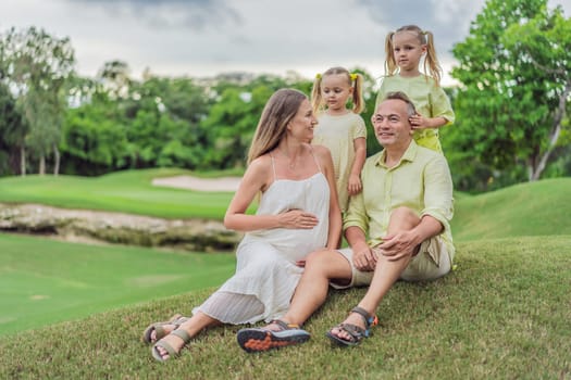 A happy family, two girls, dad, and a pregnant mom, enjoys quality time together on a lush green lawn, creating cherished memories of togetherness.