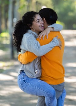 Young latin couple smiling confident hugging each other at park.