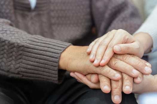 Doctors or nurses hold hands of elderly patients to support and soothe.