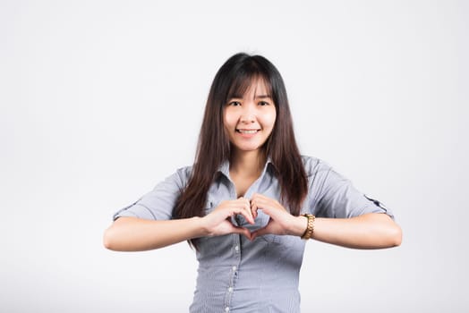 Woman smiling confidence make finger heart gesture figure symbol shape sign with two hands isolated white background, Asian happy portrait beautiful young female send love and happy valentine