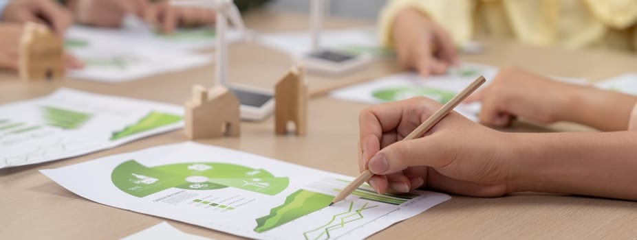 Rising graph representing the profit of using clean energy, displayed on a table at a green business meeting. Environmental documents was scattered around the table. Closeup. Delineation.