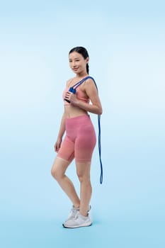 Young energetic asian woman in sportswear with jumping or skipping robe posing portrait in studio shot on isolated background. Cardio exercise tool and healthy body care lifestyle. Vigorous