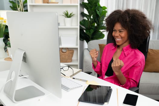 African woman blogger exited with happy face, looking on screen with valued stock market achievement at high profit. Concept of exchange investment online in trading application on pc. Tastemaker.