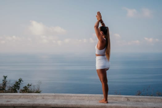 Fitness woman sea. Outdoor workout on yoga mat in park near to ocean beach. Female fitness pilates yoga routine concept. Healthy lifestyle. Happy fit woman exercising with rubber band in park.