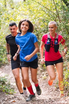 vertical photo of a happy family practicing trail running through the forest, concept of sport in nature and healthy family lifestyle