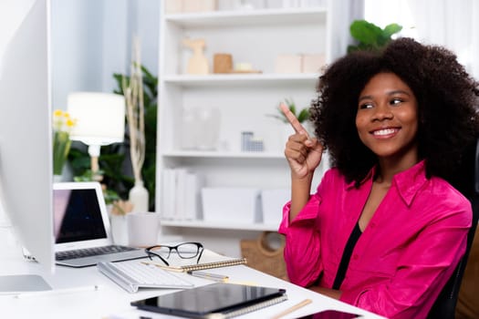 African woman smiling on happy face, looking on screen with valued achievement at high profit with newest company project. Concept of cheerful expression in work from home lifestyles. Tastemaker.