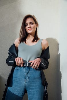 woman in jeans stands on the balcony of the house