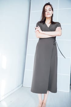 woman in a black dress stands in a bright room