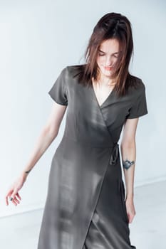 woman in a black dress stands in a bright room