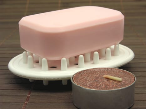 Pink soap with tealight against brown background