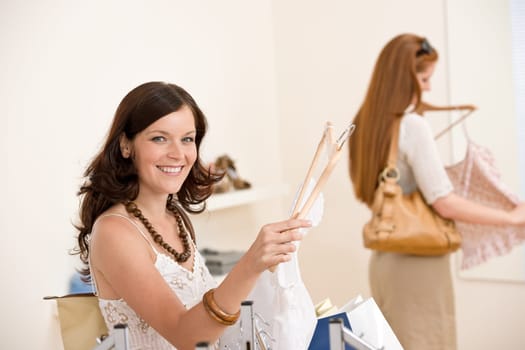 Fashion shopping - Two Happy woman choose sale clothes