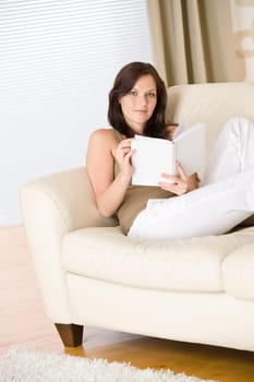 Young happy woman read book on sofa