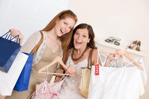 Fashion shopping - Two Happy woman choose sale clothes