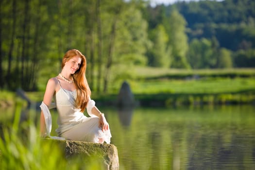 Long red hair romantic woman relax by lake