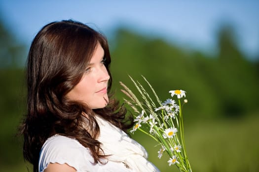 Beautiful woman with flowers on sunny day