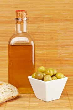 Bread, olive oil bottle and olives