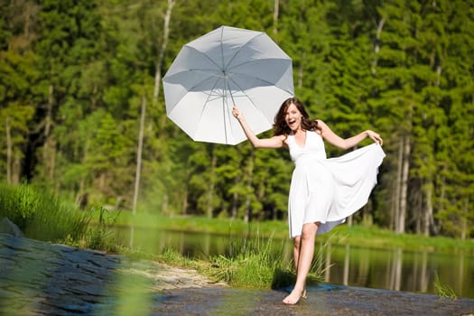 Happy romantic woman with parasol in sunlight