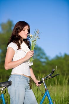 Woman with old-fashioned bike in meadow