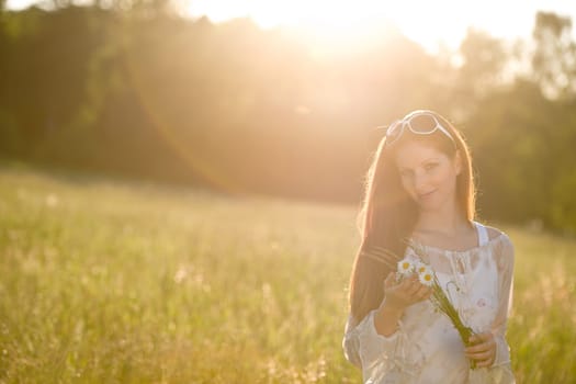 Long red hair woman in romantic sunset meadow