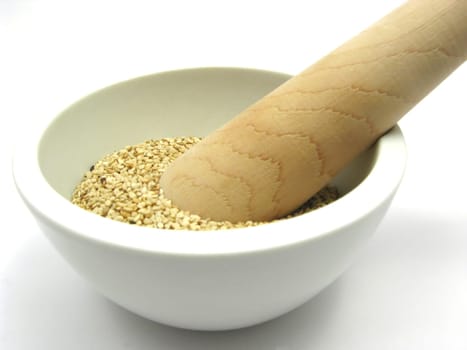 Sesame seeds in porcelain bowl with mortar