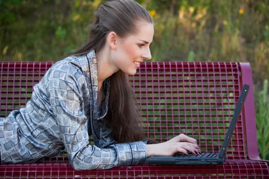 woman with laptop on the bench
