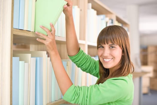 Student in library - happy woman choose book