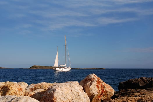 white sailboat off a coast