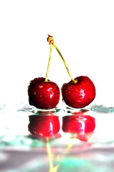 Two wet cherries on glass