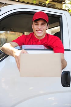 friendly parcel delivery man in a delivery car