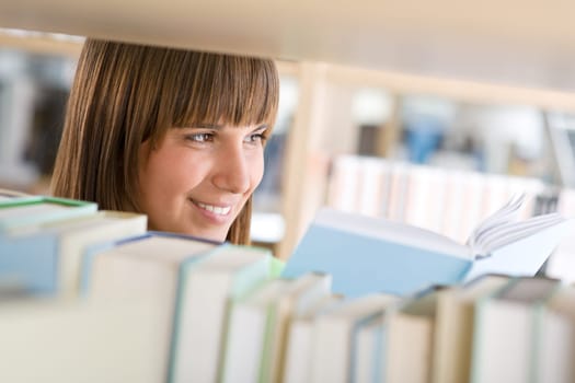 Student in library - happy woman study from book