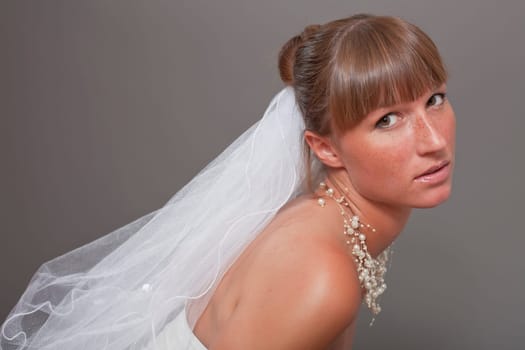 portrait of beautiful bride over grey
