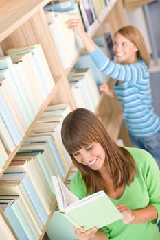 Student in library - two woman choose book