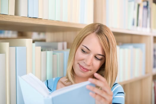 Student in library - happy woman study book