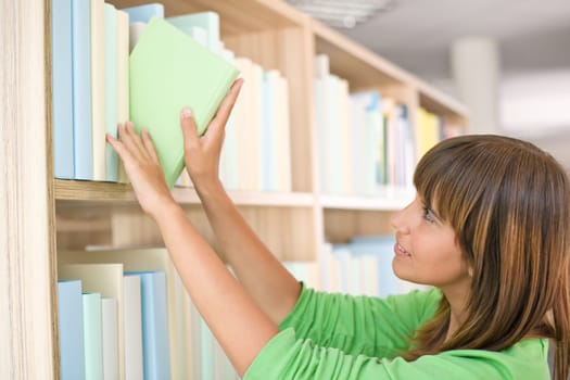 Student in library - happy woman choose book