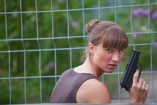 female agent with gun hiding
