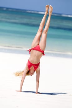 Woman doing handstand on the beach