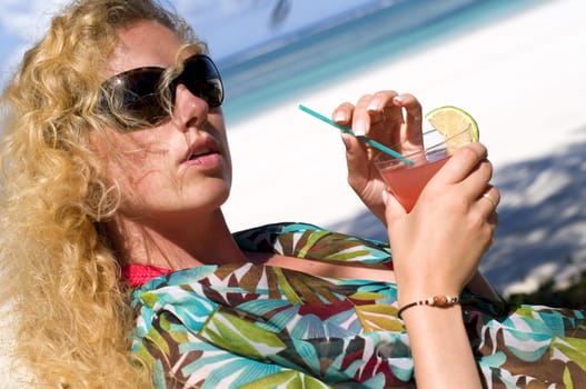 Woman with cocktail on the beach