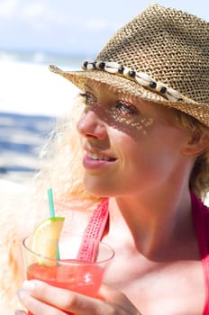 Woman with cocktail on the beach