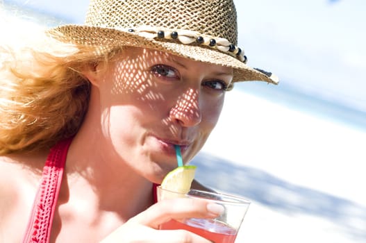 Woman with cocktail on the beach