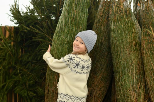 A girl buying a Christmas tree in the market.