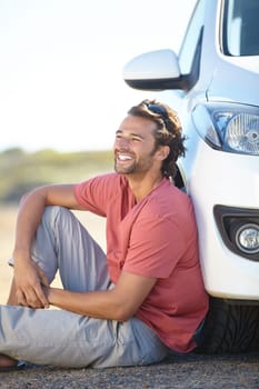 Car road trip, ground and happy man relax, sitting and smile for journey, adventure or motor transportation in Australia. Automobile, SUV vehicle and person smile, rest and break on outdoor dirt road.