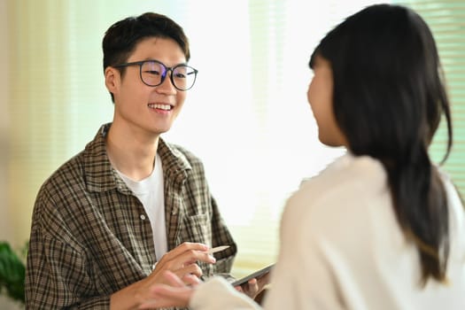 Two asian college students having break after classes and talking to each other. Youth lifestyle concept.