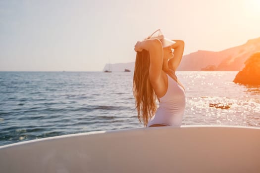 Close up shot of happy young caucasian woman looking at camera and smiling. Cute woman portrait in bikini posing on a volcanic rock high above the sea