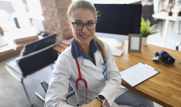 Portrait of cheerful doctor in uniform, stethoscope tool on neck, modern clinic office. Professional specialist at work. Health, medicine, intern concept