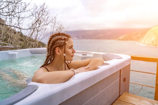 Take time for yourself. Outdoor swimsuit with mountain and sea views. A woman in a black swimsuit is relaxing in the hotel pool, admiring the view.