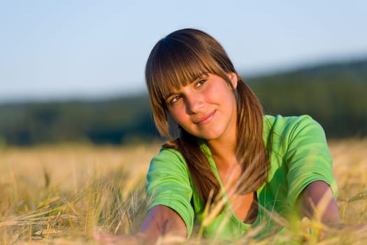 Young woman in sunset corn field