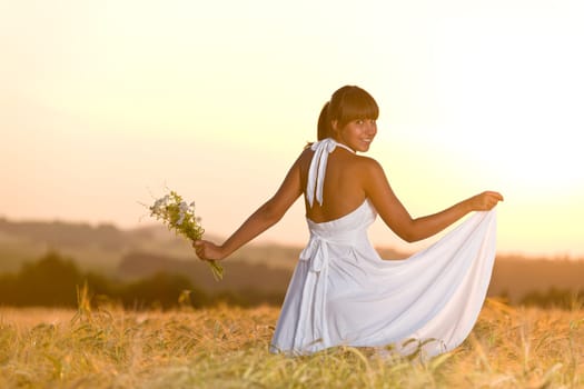 Romantic woman in sunset corn field wear dress
